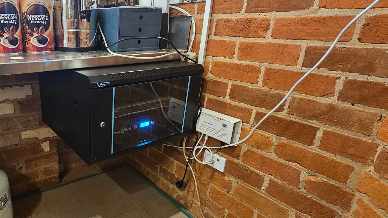 Commercial CCTV recorder and protected power equipment installed in a wall-mounted network rack
