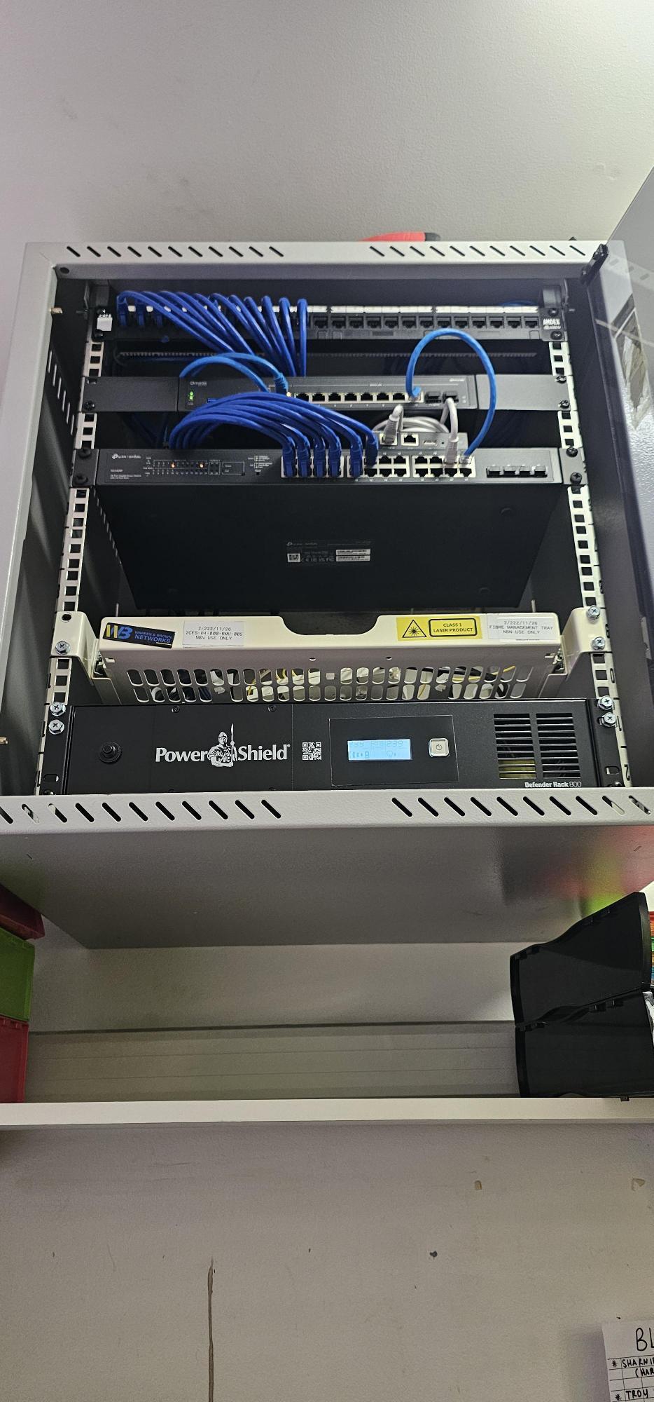 The same motel network rack after rebuild by Dubbo IT and Security - patch panel, managed switch, dressed patch leads and rack-mounted UPS